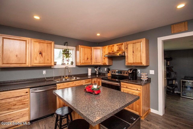 kitchen featuring sink, a center island, stainless steel appliances, dark hardwood / wood-style flooring, and a breakfast bar area