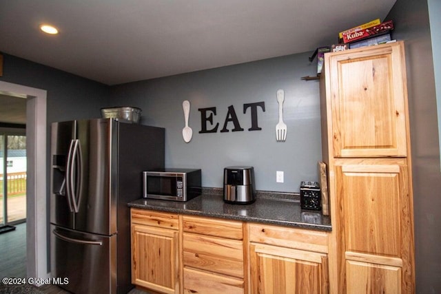 kitchen featuring light brown cabinetry, stainless steel appliances, and hardwood / wood-style flooring