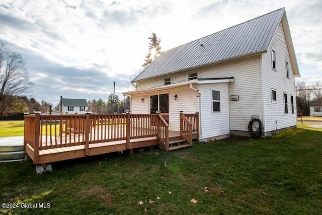 back of property with a lawn and a wooden deck