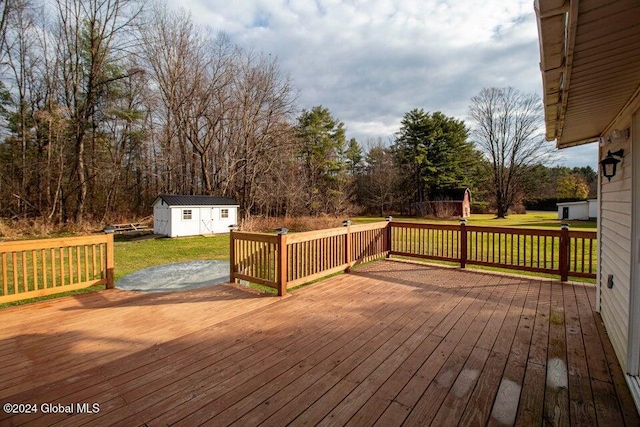 wooden deck featuring a lawn and a storage unit