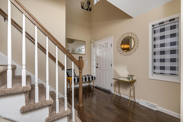 entrance foyer featuring dark hardwood / wood-style flooring and an inviting chandelier