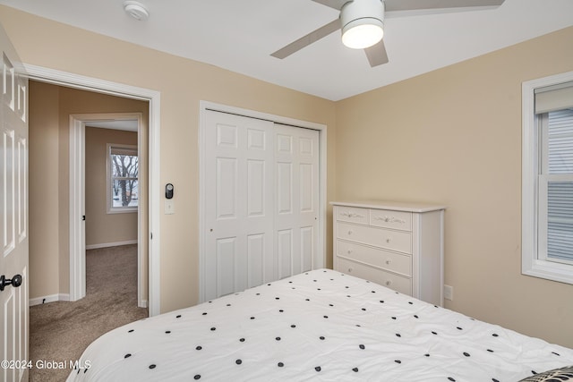 carpeted bedroom with ceiling fan and a closet