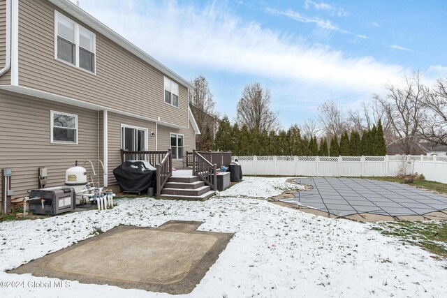 snowy yard featuring a patio area and a pool side deck