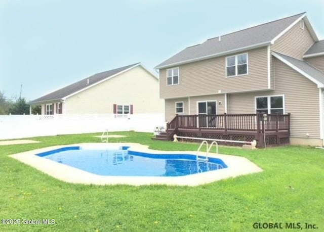 rear view of house with a yard and a swimming pool side deck