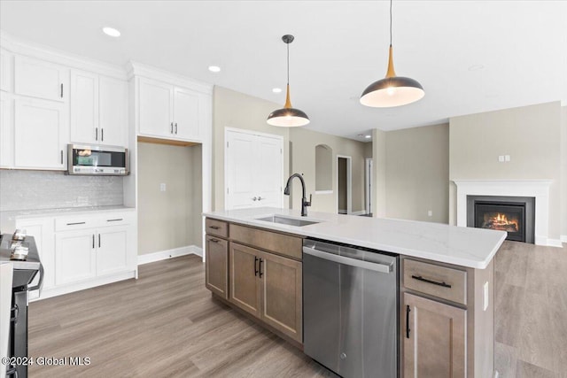 kitchen with pendant lighting, sink, white cabinetry, and stainless steel appliances