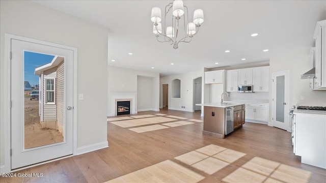 kitchen featuring pendant lighting, a kitchen island with sink, sink, appliances with stainless steel finishes, and white cabinetry