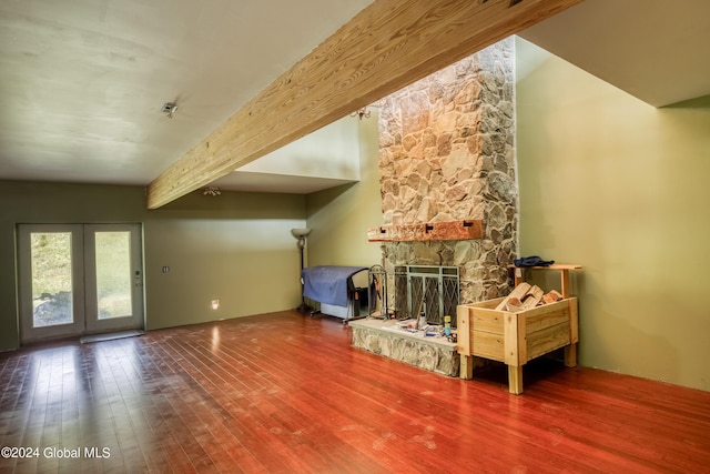 living room with a fireplace, beam ceiling, and hardwood / wood-style flooring