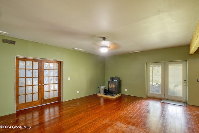 misc room with french doors, a wood stove, ceiling fan, and hardwood / wood-style floors