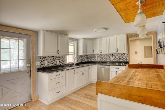 kitchen featuring dishwasher, butcher block counters, sink, hanging light fixtures, and white cabinetry