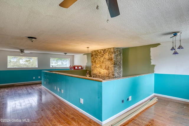 kitchen featuring a textured ceiling, dark hardwood / wood-style floors, and hanging light fixtures