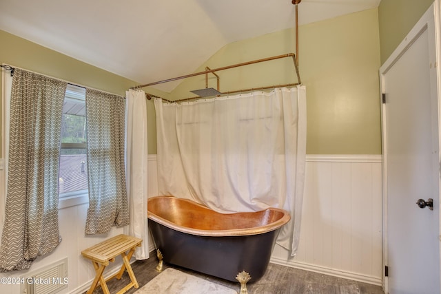 interior space with hardwood / wood-style floors, independent shower and bath, and vaulted ceiling