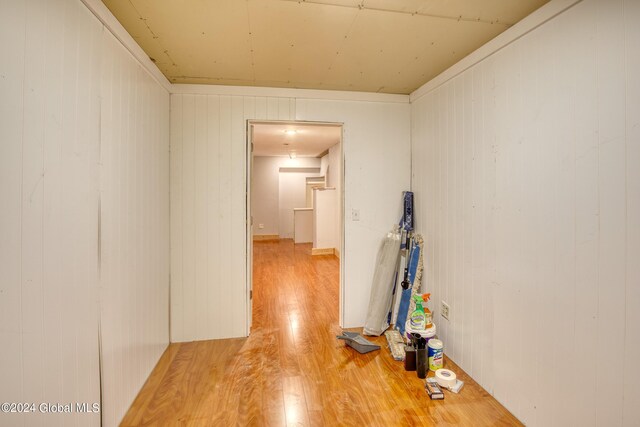 hallway featuring hardwood / wood-style floors and wooden walls