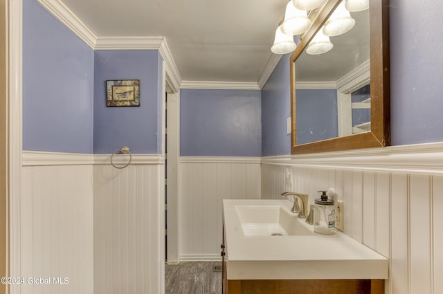 bathroom with hardwood / wood-style flooring, vanity, and ornamental molding