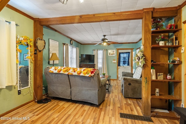 living room featuring light wood-type flooring, ceiling fan, and ornamental molding