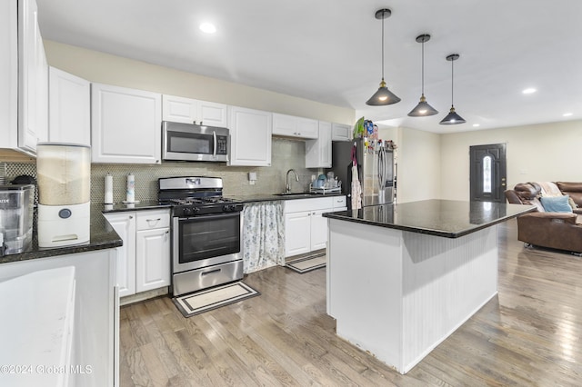 kitchen featuring white cabinetry, backsplash, appliances with stainless steel finishes, and light hardwood / wood-style flooring