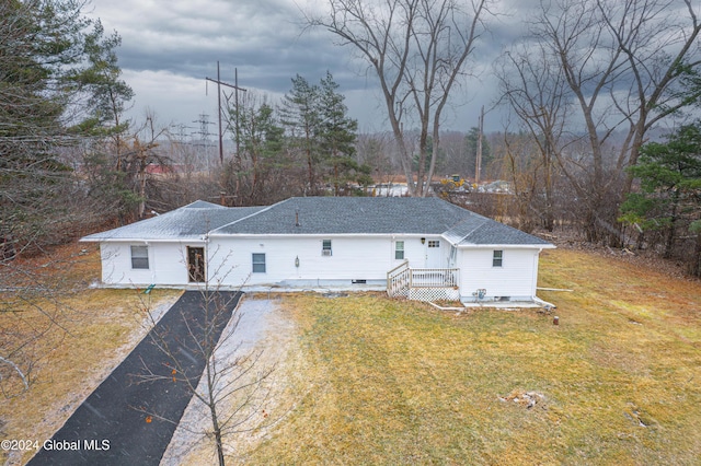 rear view of property featuring a lawn and a deck