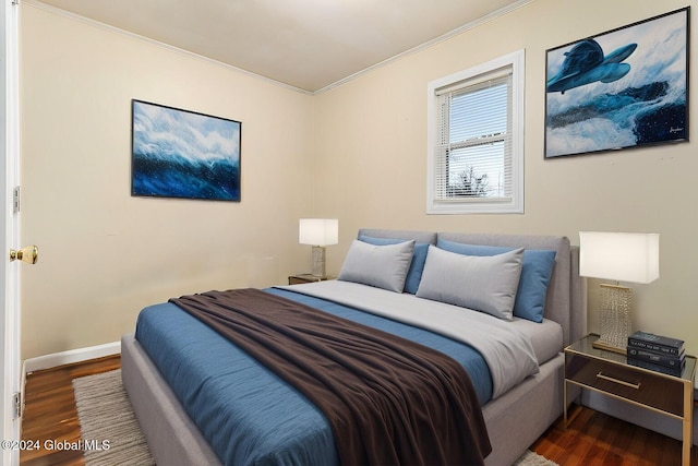 bedroom featuring ornamental molding and dark wood-type flooring