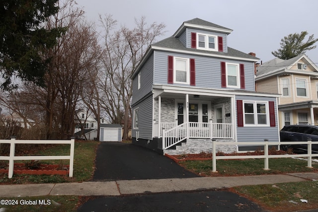 view of front facade featuring an outbuilding, a porch, and a garage