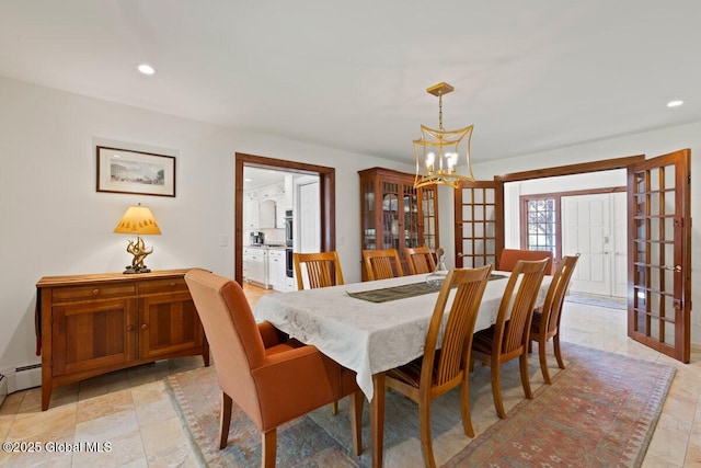 dining room with a chandelier, a baseboard radiator, and french doors