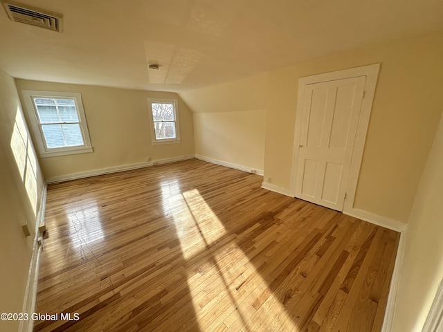 bonus room with light hardwood / wood-style floors and lofted ceiling