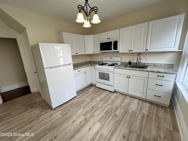 kitchen with white appliances, sink, pendant lighting, white cabinets, and light hardwood / wood-style floors