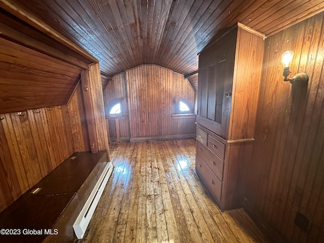 additional living space with wood walls, wood ceiling, lofted ceiling, and a baseboard heating unit