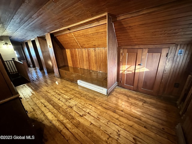 bonus room with vaulted ceiling, baseboard heating, wooden walls, hardwood / wood-style flooring, and wooden ceiling