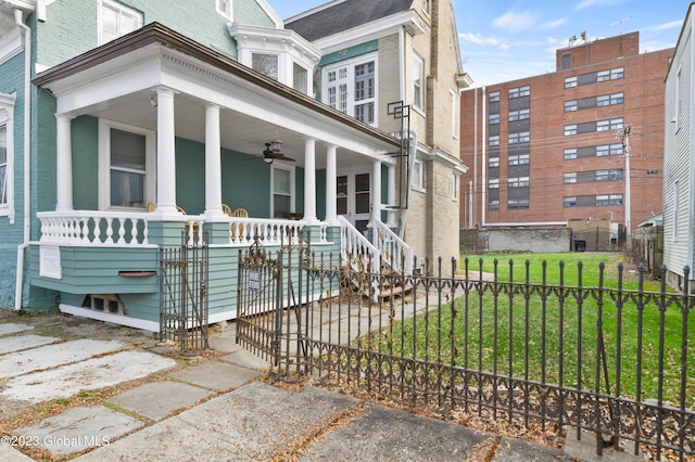 view of front of house with ceiling fan, a porch, and a front yard