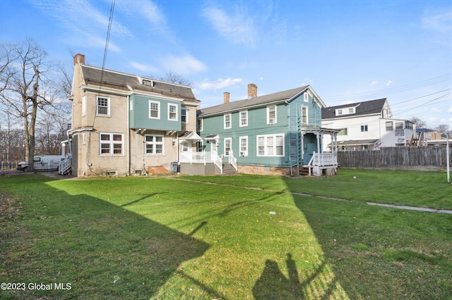 rear view of property featuring a lawn