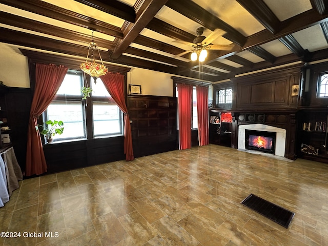 unfurnished living room featuring beamed ceiling, ceiling fan with notable chandelier, coffered ceiling, and a high end fireplace