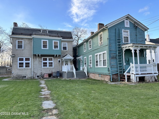 back of house featuring covered porch, central AC, and a lawn