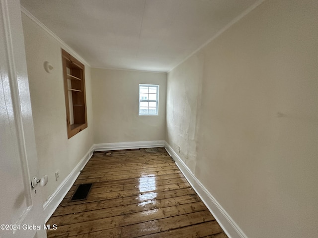 unfurnished room with ornamental molding and dark wood-type flooring