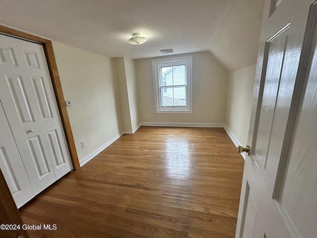 additional living space featuring lofted ceiling and hardwood / wood-style flooring