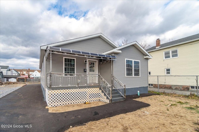 rear view of property with a wooden deck and fence