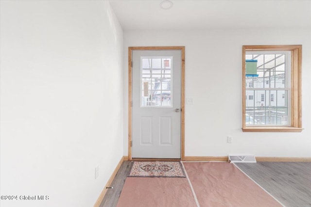 doorway to outside with visible vents, baseboards, and wood finished floors