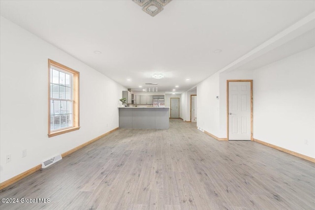 unfurnished living room with recessed lighting, visible vents, baseboards, and light wood finished floors