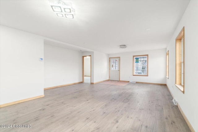 spare room featuring light wood-style floors and baseboards