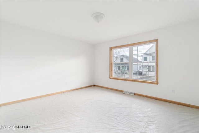 carpeted empty room with visible vents and baseboards