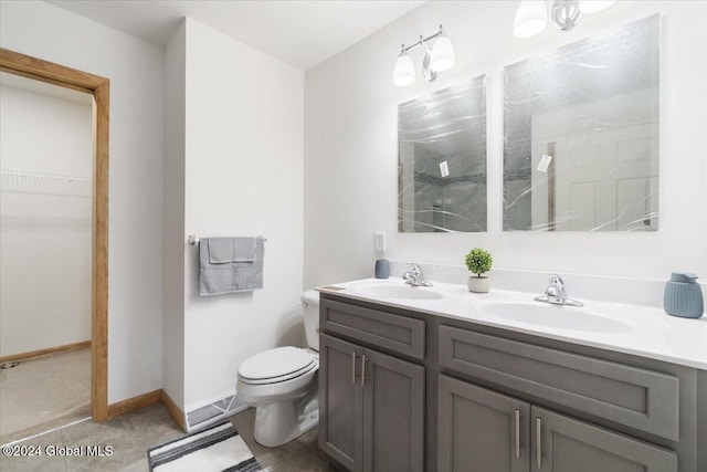 bathroom featuring double vanity, toilet, a shower, and a sink