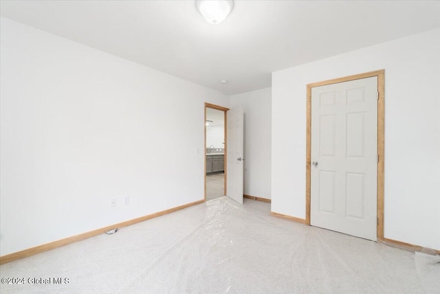 unfurnished bedroom with baseboards and a sink