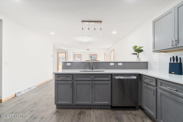 kitchen featuring visible vents, gray cabinets, a sink, a peninsula, and dishwasher