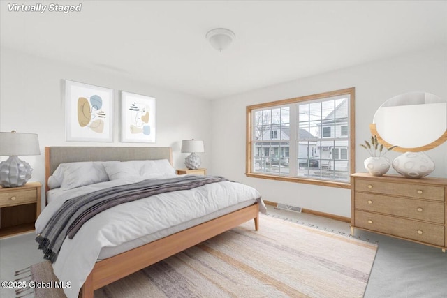 carpeted bedroom featuring visible vents and baseboards