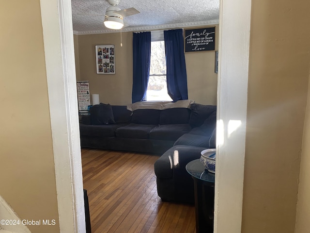 living room with ceiling fan, wood-type flooring, and a textured ceiling