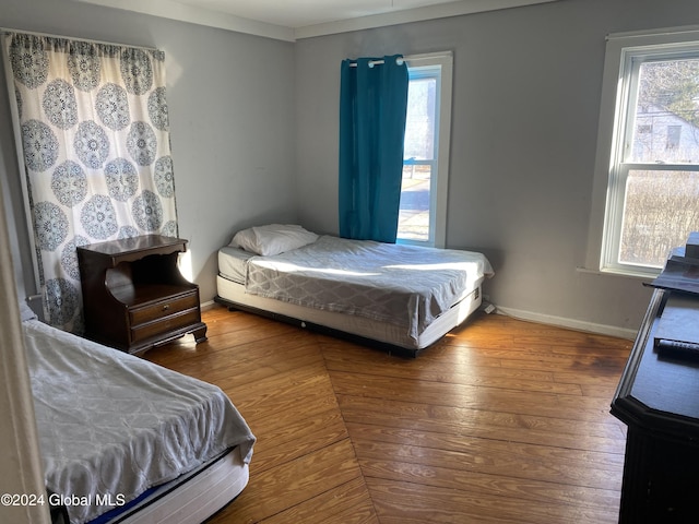 bedroom with hardwood / wood-style flooring and multiple windows