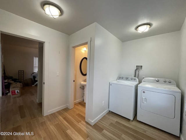 laundry area featuring washer and dryer and light hardwood / wood-style flooring