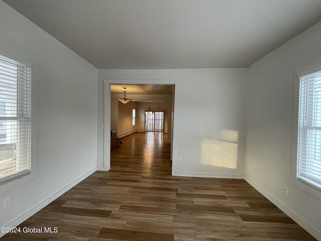 spare room featuring dark hardwood / wood-style flooring and an inviting chandelier