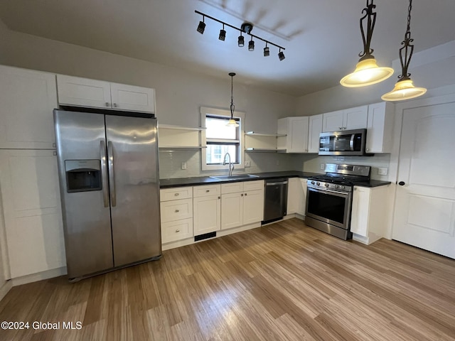 kitchen with white cabinets, pendant lighting, stainless steel appliances, and sink