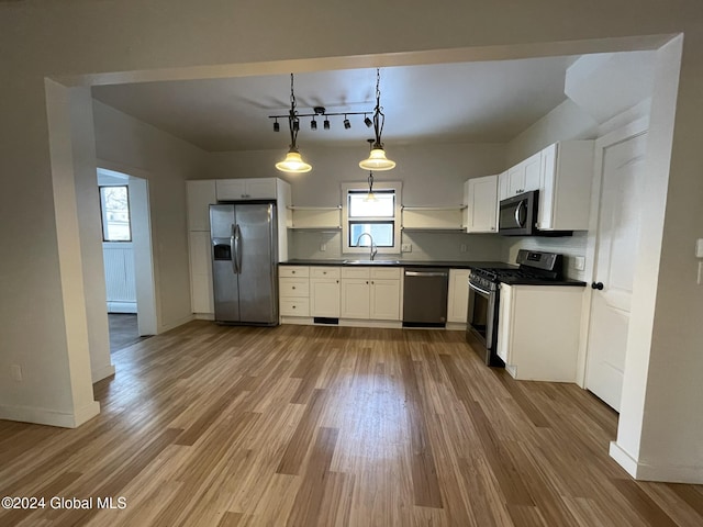 kitchen featuring pendant lighting, a healthy amount of sunlight, stainless steel appliances, and hardwood / wood-style flooring