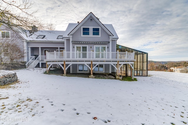 snow covered rear of property featuring a deck