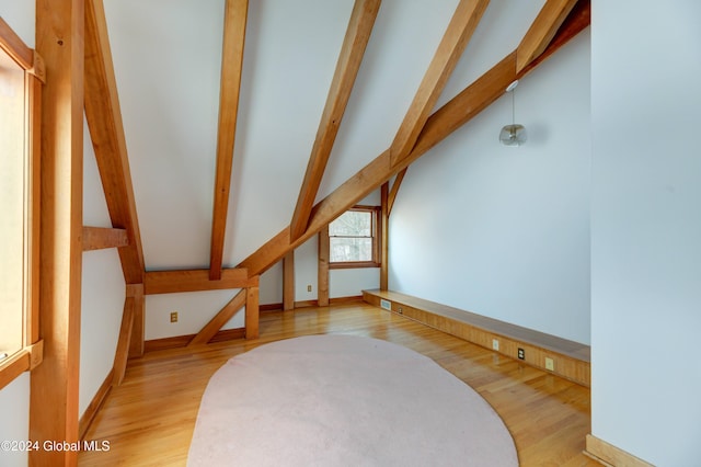 bonus room featuring lofted ceiling with beams and light wood-type flooring